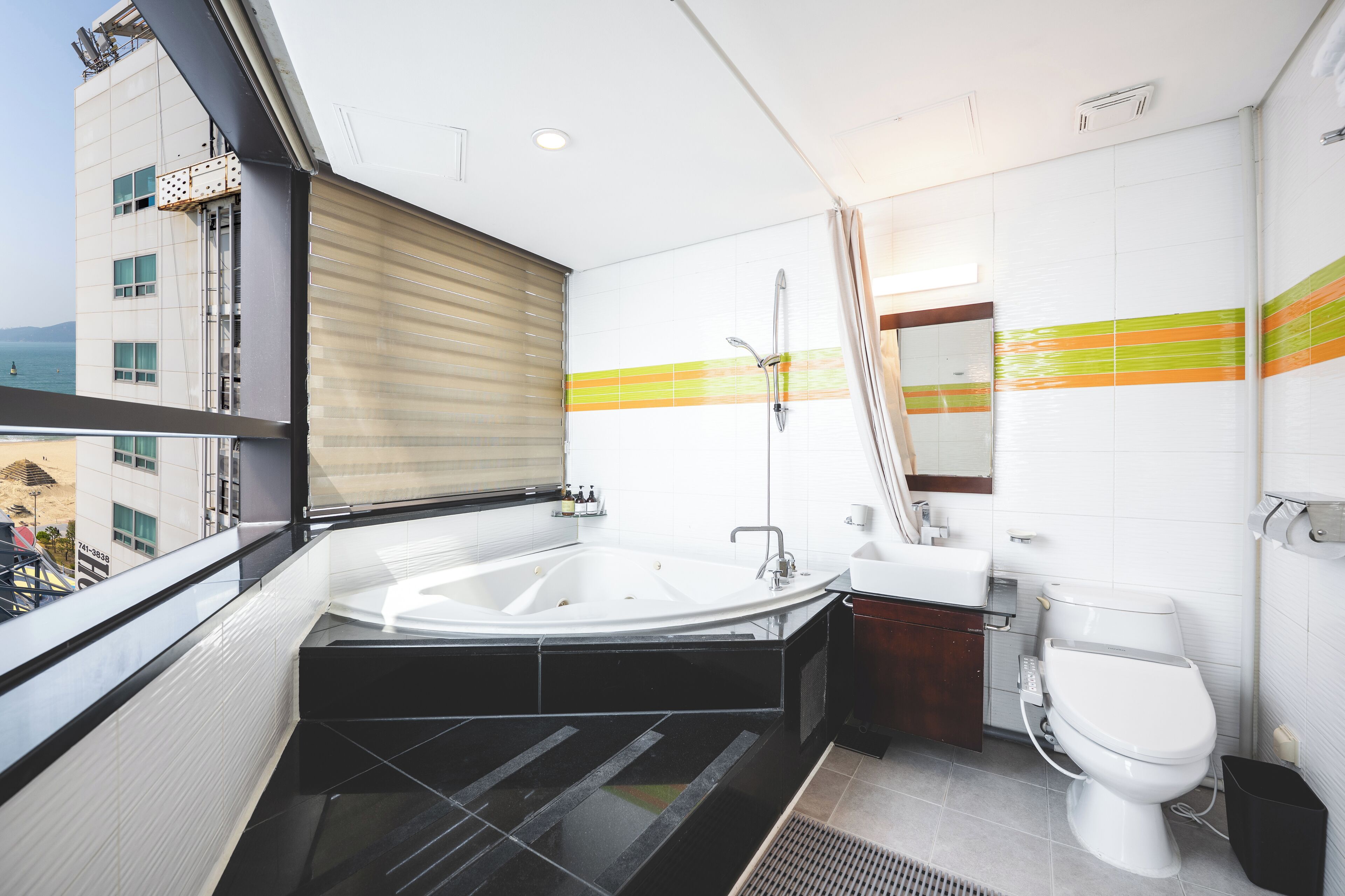 A modern bathroom with a bathtub, toilet, and sink.