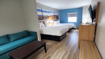 Una habitación de hotel con cama, sofá, escritorio y televisión.