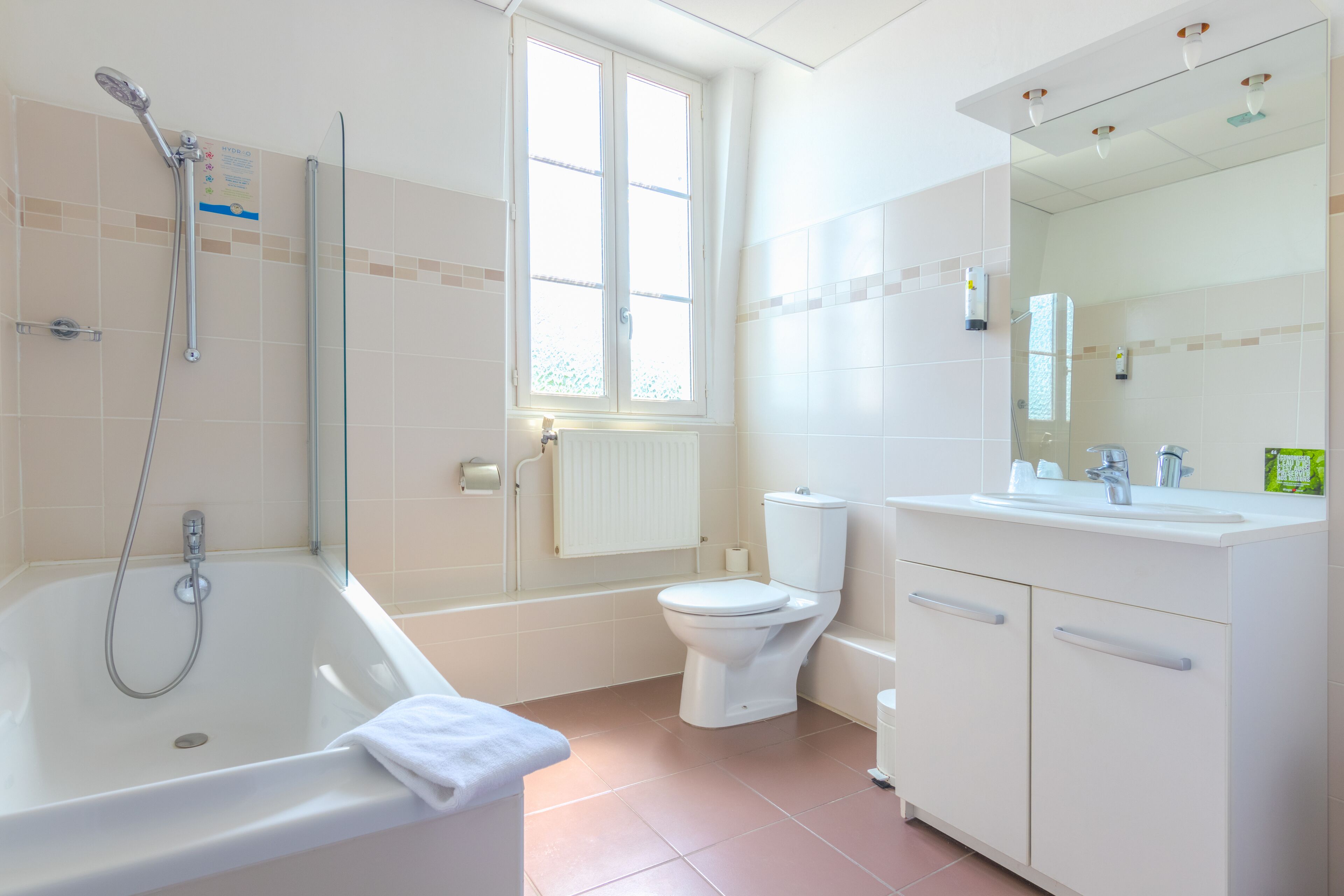 Et moderne badeværelse med badekar, toilet og vaskemøbel.