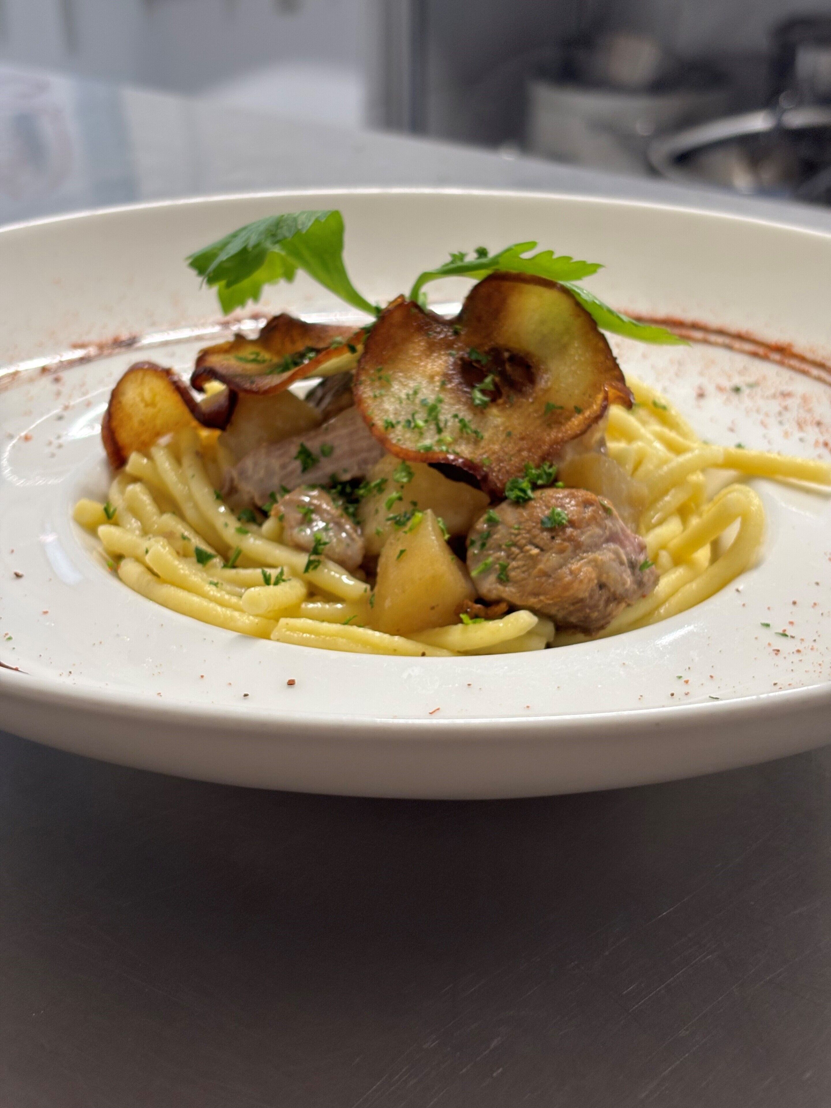 En tallrik pasta med kött och svamp.