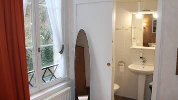 A bathroom with a window, a sink, and a mirror.