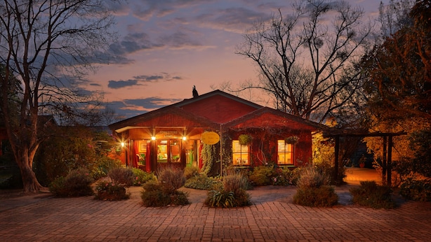 A rustic lodge with a brick facade, a covered porch, and a well-maintained garden. - The Foresters Arms (Mhlambanyatsi)