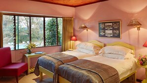 A bedroom with two beds, a desk, a chair, and a window with curtains. - The Foresters Arms (Mhlambanyatsi)