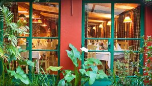 A restaurant with a red exterior and green-framed windows. - The Foresters Arms (Mhlambanyatsi)
