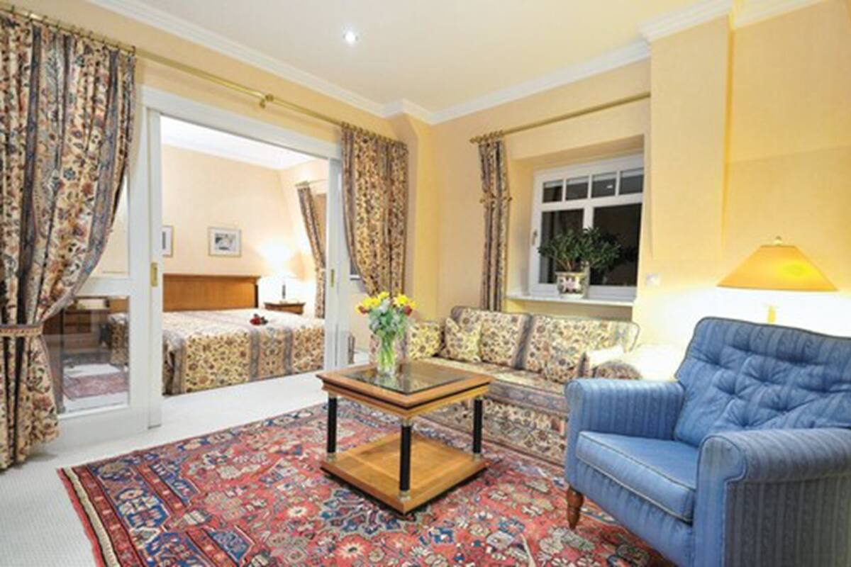 A living room with a sofa, a coffee table, and a patterned rug.