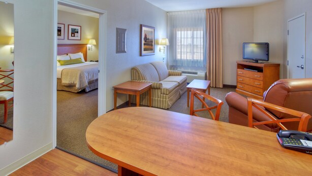 A hotel room with a bed, a sofa, a TV, a desk, and a dining table. - Candlewood Suites Ft Stockton by IHG (Fort Stockton)