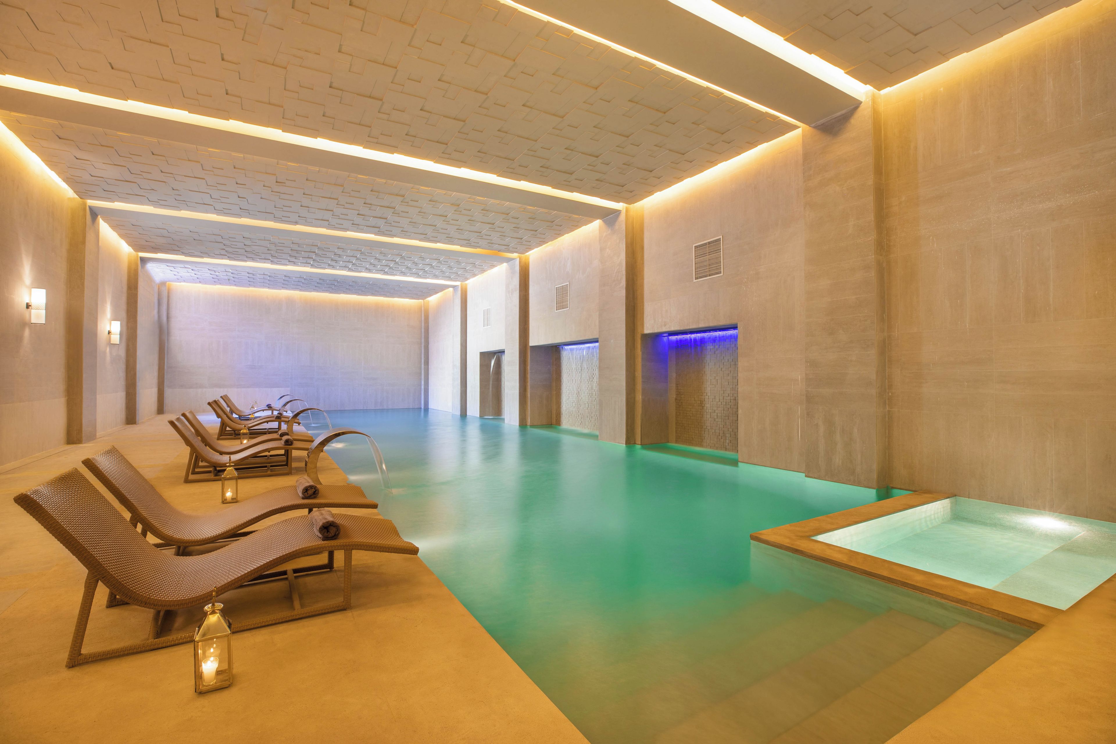 A spa area with a pool, loungers, and a massage table.