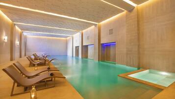 A spa area with a pool, loungers, and a massage table.