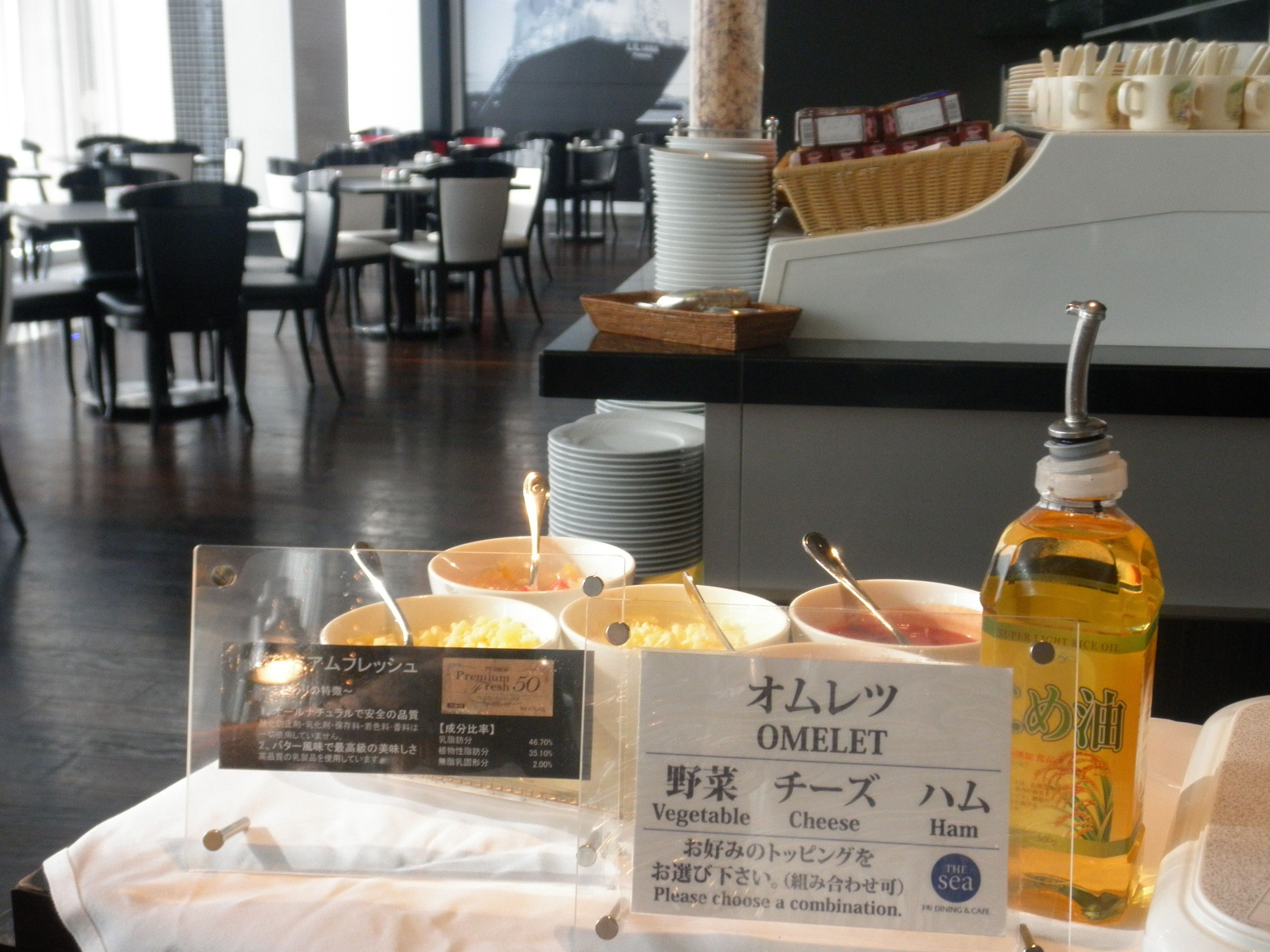 Ein Frühstücksbuffet mit beschrifteten Speisen und einer Öldose.