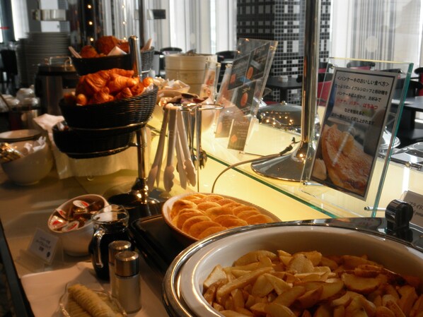A buffet with various food items including fruits, pastries, and a bowl of sliced apples. - New Otani Inn Yokohama Premium (Yokohama)