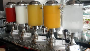 Dispensador de bebidas com várias opções, incluindo suco de laranja.