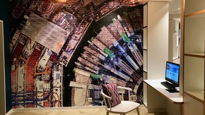 Um espaço de escritório moderno com um mural de parede de tijolos, uma mesa branca, um computador e uma cadeira.