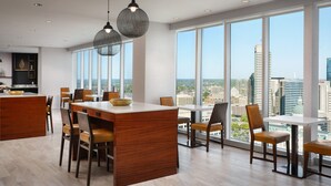 A modern dining area with a central island, large windows offering city views, and pendant lighting. - JW Marriott Indianapolis (Indianapolis)