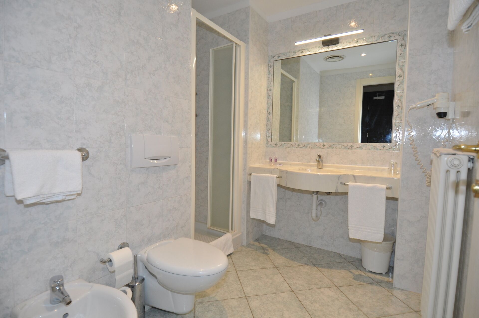 A modern bathroom with a toilet, sink, and shower.