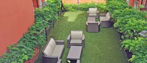 A rooftop garden with outdoor seating and lush greenery.