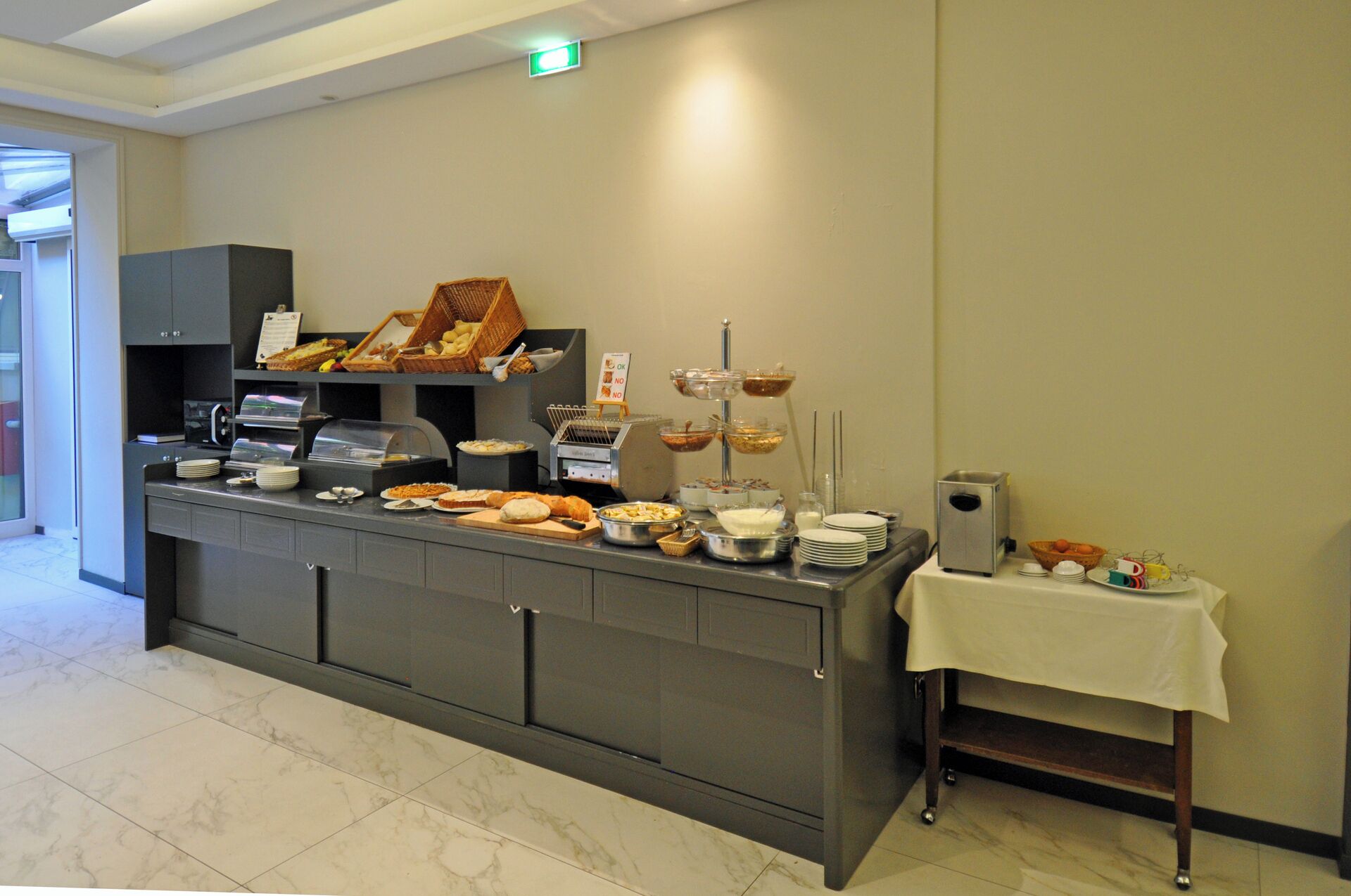 A buffet setup with various food items and a coffee machine.