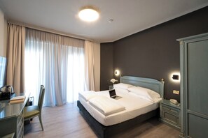 A hotel room with a bed, a desk, a chair, and a wardrobe. - Cavour 30TRE - Hotel Moderno (Stresa)