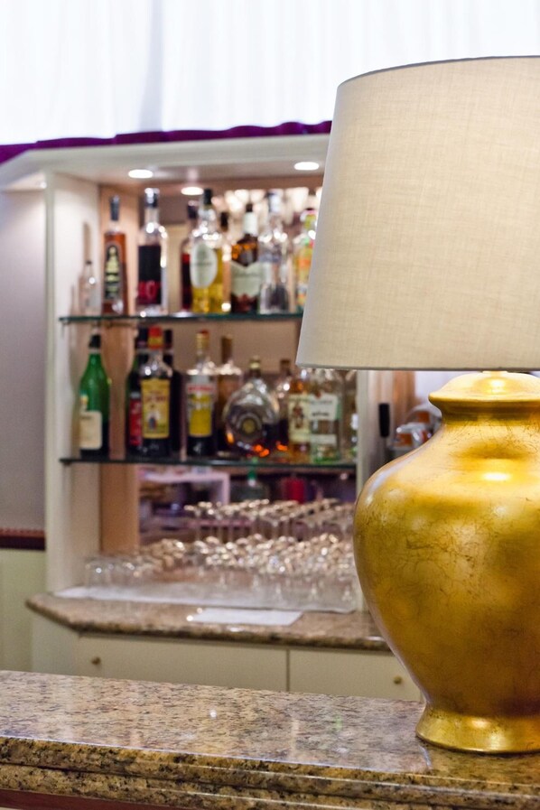A bar area with a variety of liquor bottles and glasses on shelves.