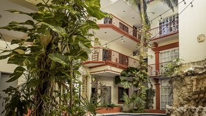 A multi-level building with balconies, a pool, and lush greenery. - Hotel Maya Turquesa - Playa del Carmen (Playa del Carmen)