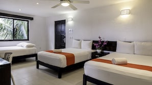 A hotel room with two beds, a desk, a chair, a ceiling fan, and a window with a view of palm trees. - Hotel Maya Turquesa - Playa del Carmen (Playa del Carmen)
