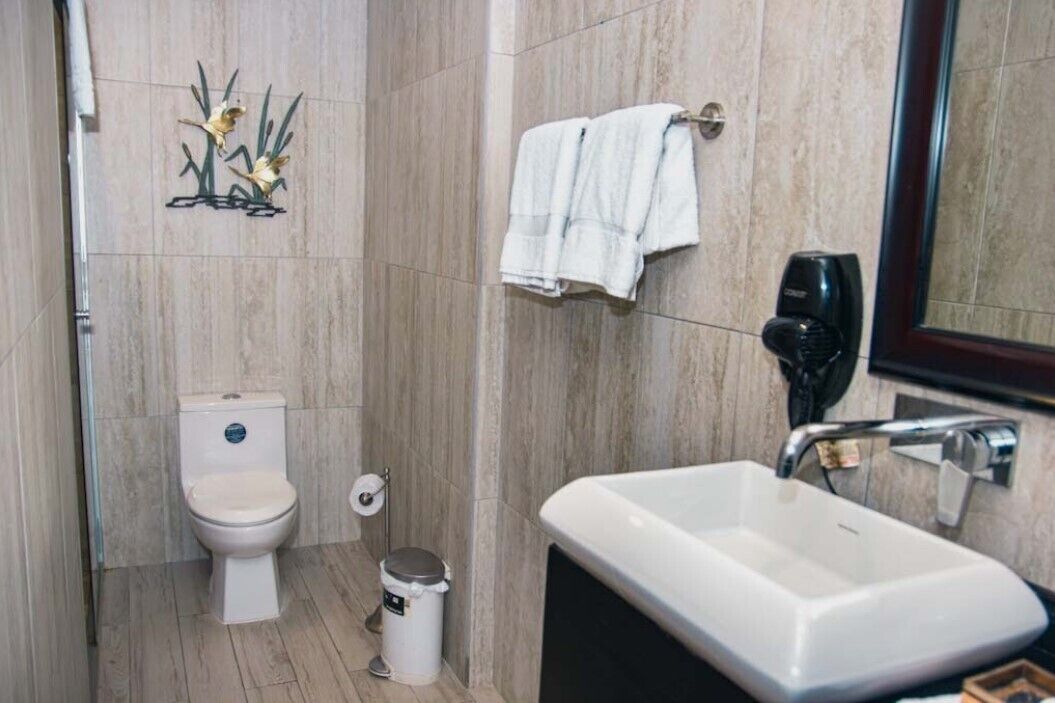A bathroom with a toilet, sink, and towel rack.
