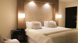 Ein Hotelzimmer mit einem großen Bett, zwei Nachttischen und einer Tür.