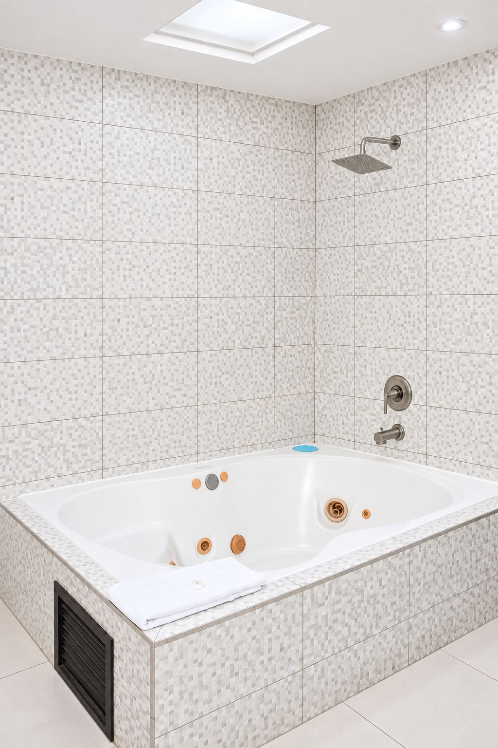 Un baño moderno con una bañera independiente, un cabezal de ducha y un tragaluz.