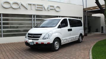 A white van parked in front of a building with the sign "CONTEMPO".