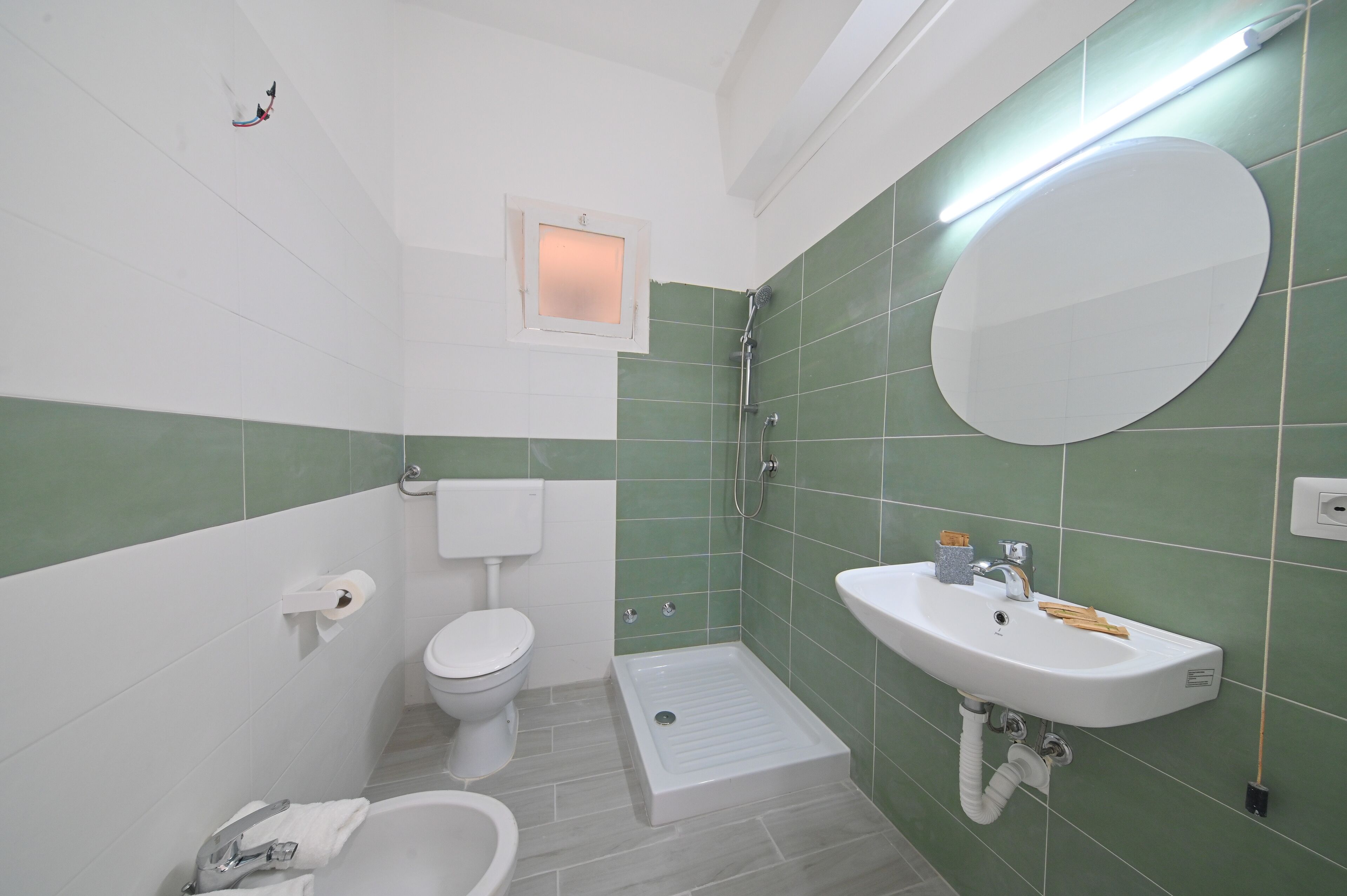Un baño con inodoro, lavabo, espejo y bidé.