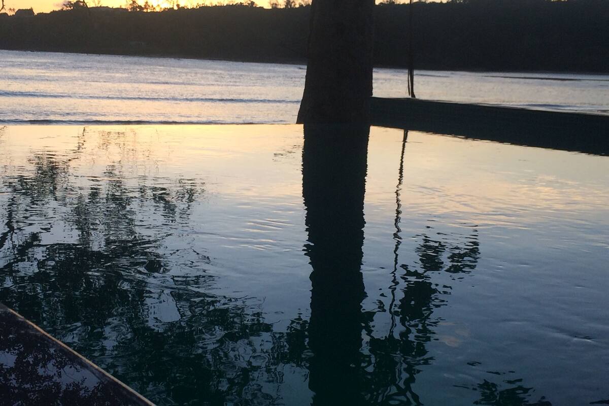 Rustig water dat bomen en een gebouw weerspiegelt.