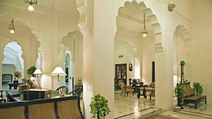 A lobby with a reception desk, seating area, and decorative arches.