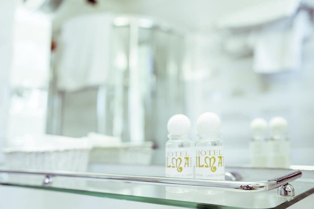 Un mini-bar d’hôtel contenant des bouteilles étiquetées « HÔTEL LISA » et un plateau en verre.