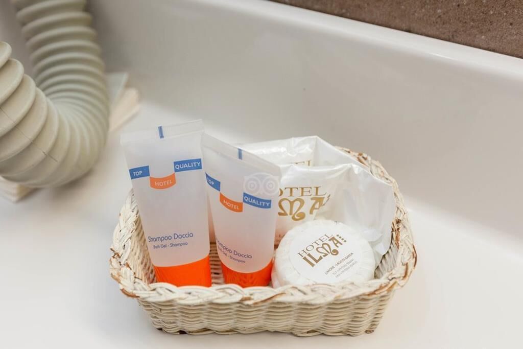 A wicker basket containing hotel toiletries, including shampoo and body lotion.
