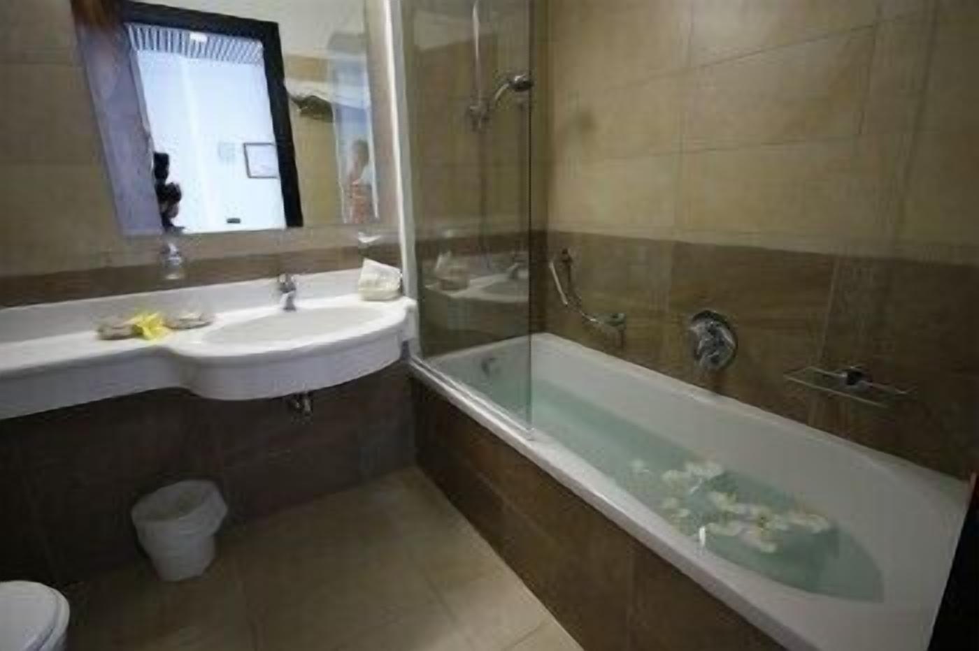 Une salle de bain avec un lavabo, un miroir et une baignoire.