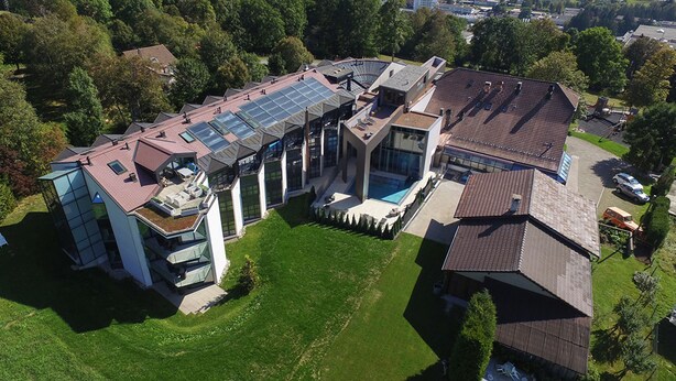An aerial view of a modern house with a swimming pool, large glass windows, and solar panels. - Grand Hôtel Les Endroits (La Chaux-de-Fonds)