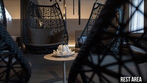 A modern interior with hanging chairs and a central table, labeled as a rest area. - Grand Hôtel Les Endroits (La Chaux-de-Fonds)