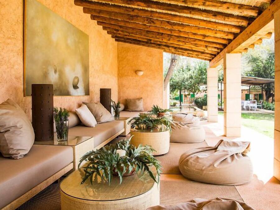 A cozy, well-lit lounge area with a wooden ceiling, comfortable seating, and a large painting on the wall.