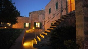 A stone building with a staircase leading to a second floor. - Hotel Rural Son Bernadinet (Campos)