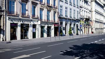 A street view of a row of buildings with a hotel named "HOTEL BAYARD" and an art gallery named "Artclub Gallery."