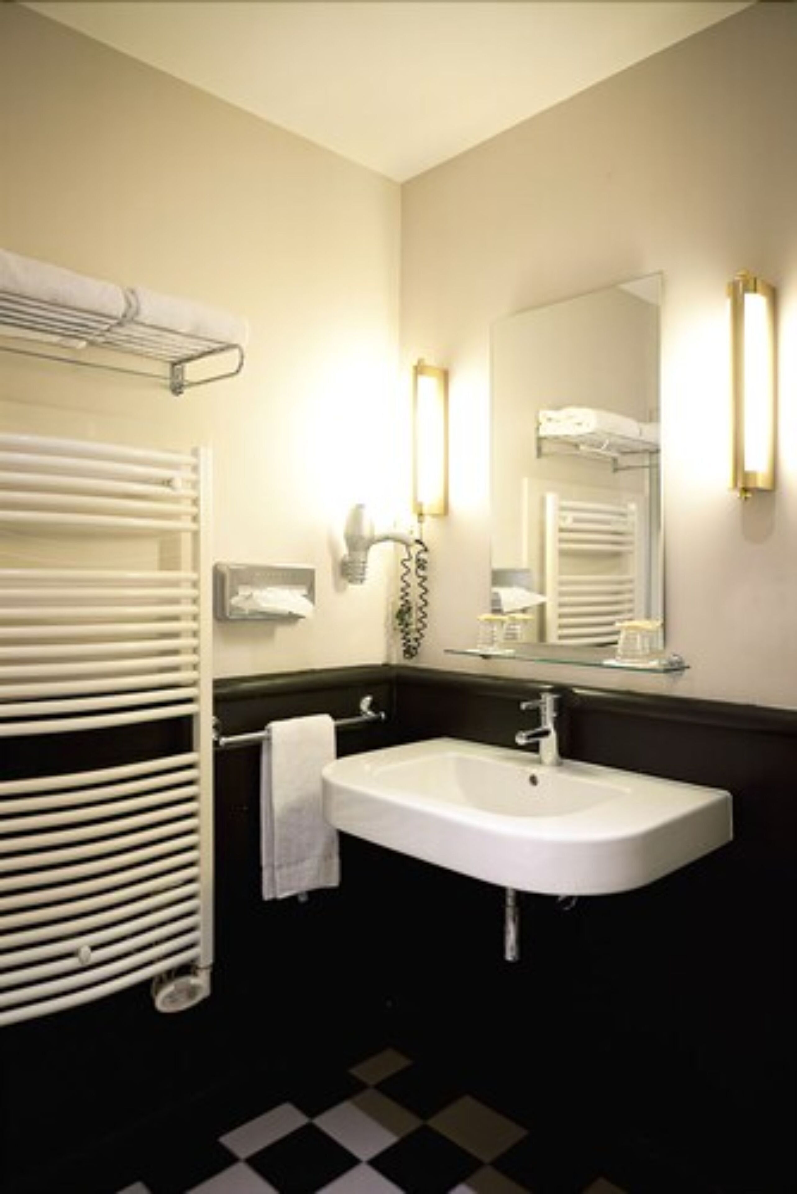 Un baño con un lavamanos blanco, toallero, espejo y radiador.