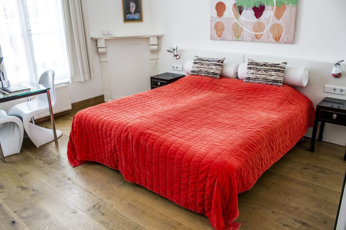 A bedroom with a large bed, a desk, and a chair.