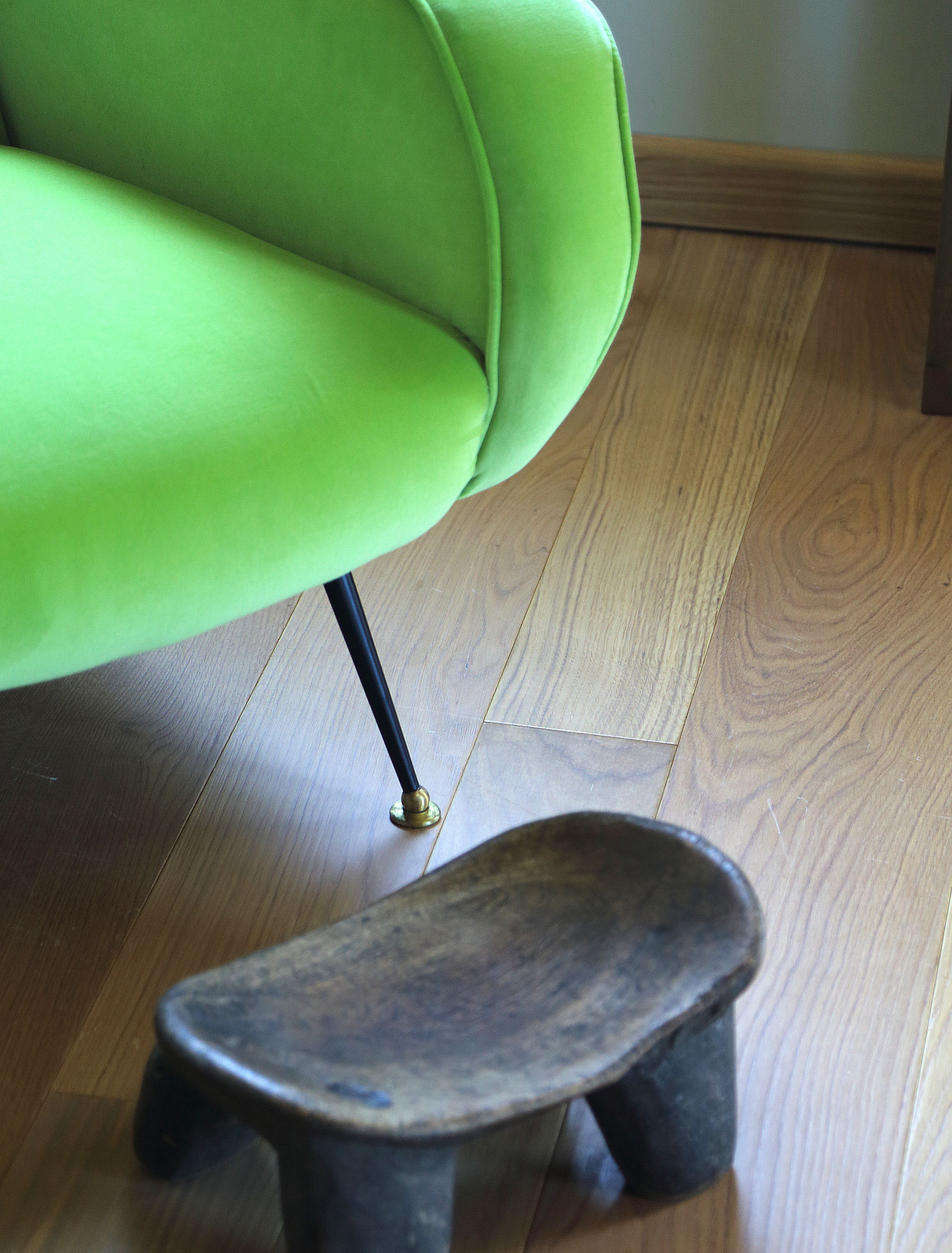 A green chair with a wooden floor.