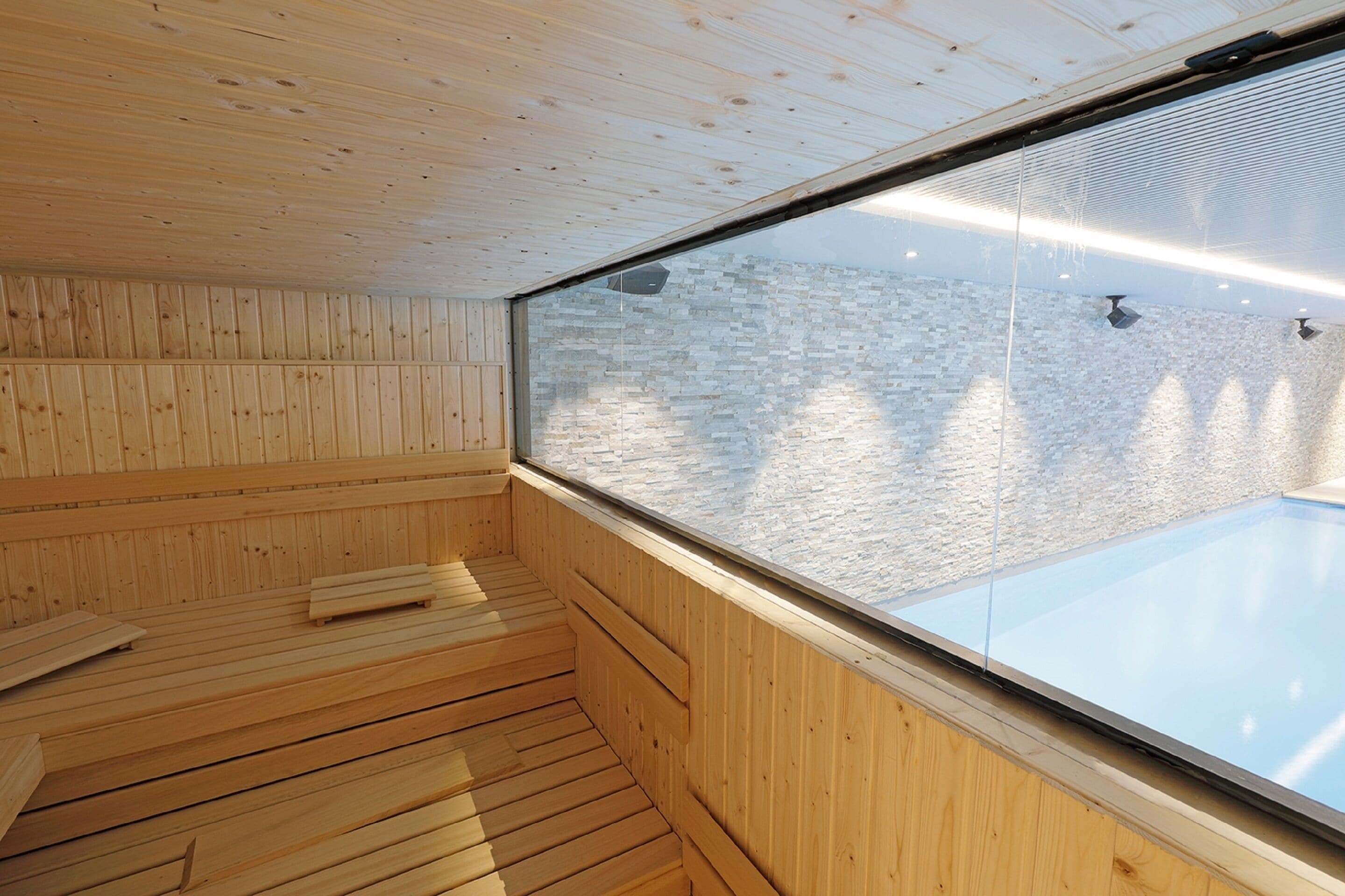 Un sauna aux murs en bois et doté d’une fenêtre en verre.