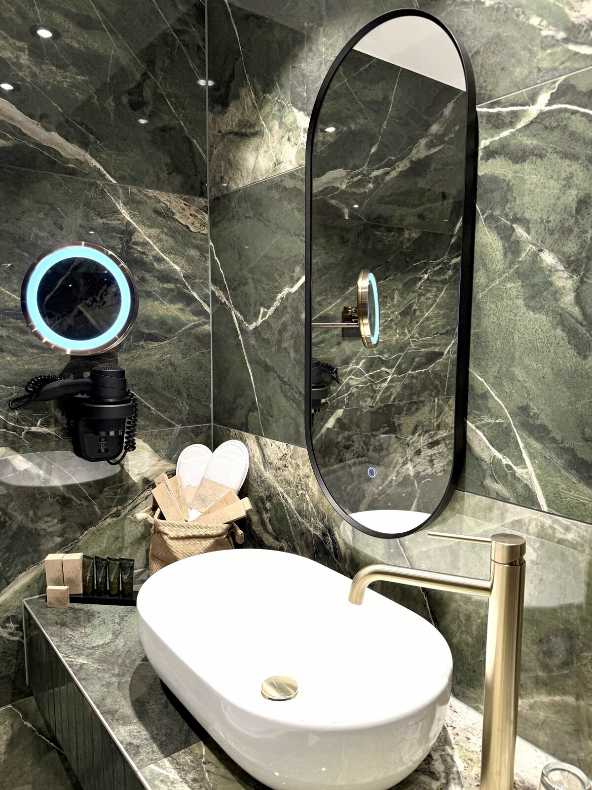 A bathroom with a white sink, a large mirror, and a camera setup.