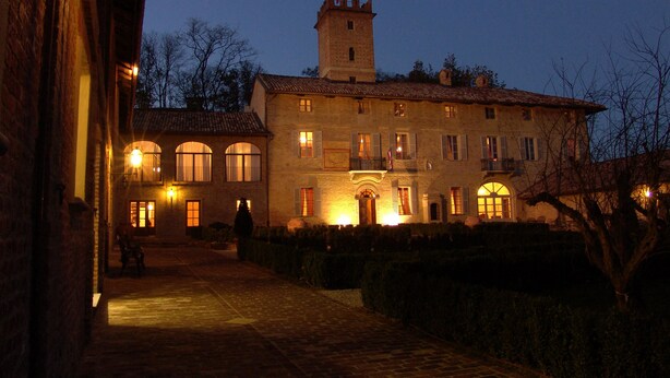 A historic building with a tower, arched windows, and a courtyard at dusk. - Castello di Razzano, The Originals Relais (Relais du Silence) (Alfiano Natta)