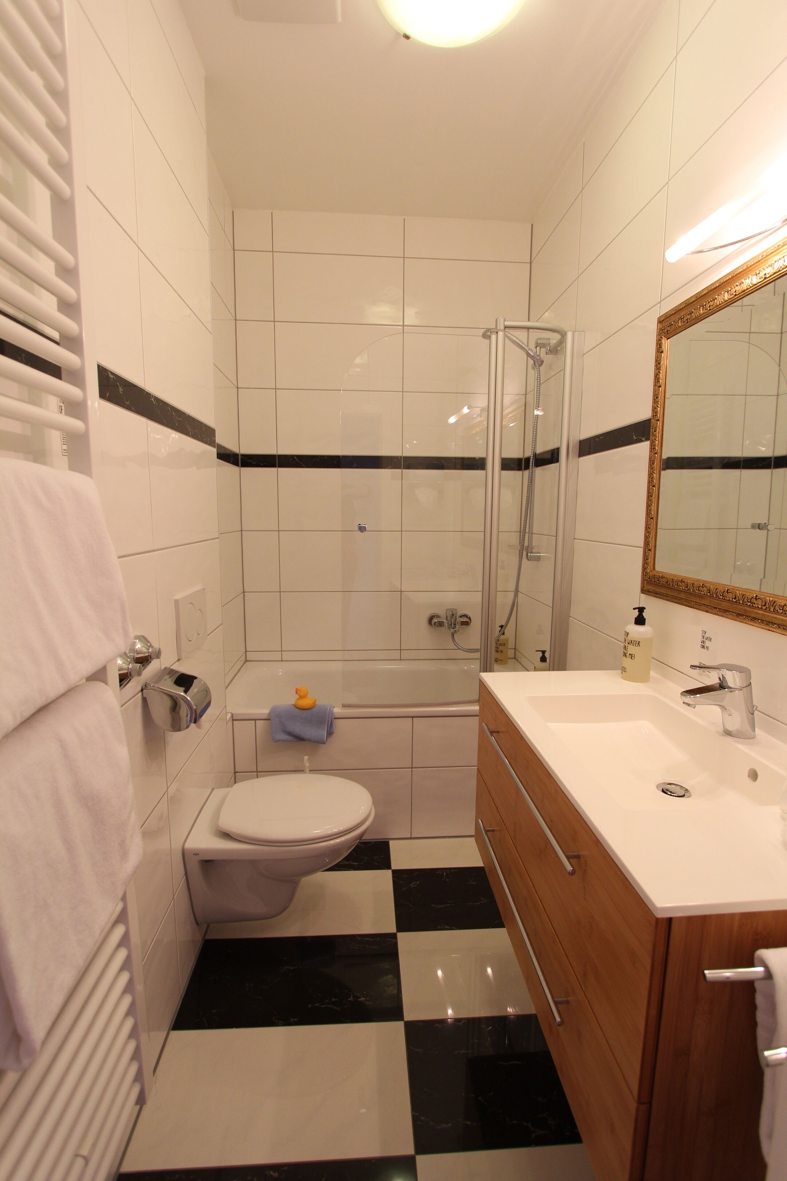 A bathroom with a toilet, sink, and shower.