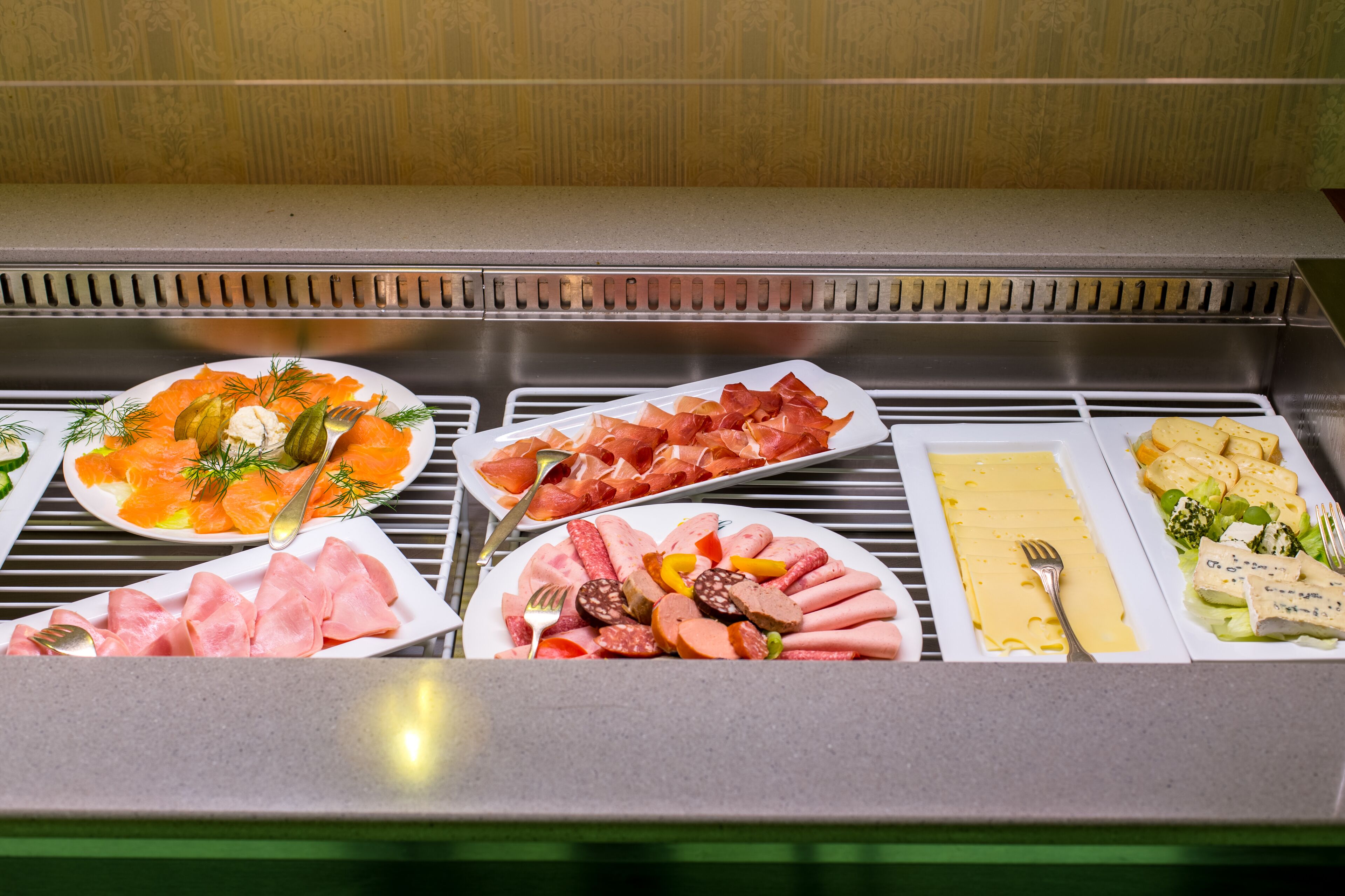 A buffet with various food items including smoked salmon, ham, and cheese.