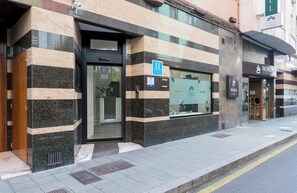 A hotel entrance with a glass door, a blue handicap accessibility sign, and a 'COSTA VERDE' sign above the door. - Hotel Costa Verde (Gijon)