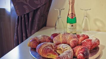 Una mesa con cruasanes y una botella de vino.
