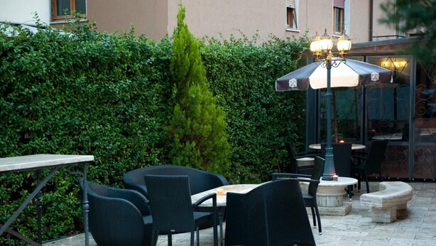An outdoor patio area with wicker furniture, a table, and a lamp. - Il Monte (Monte San Savino)